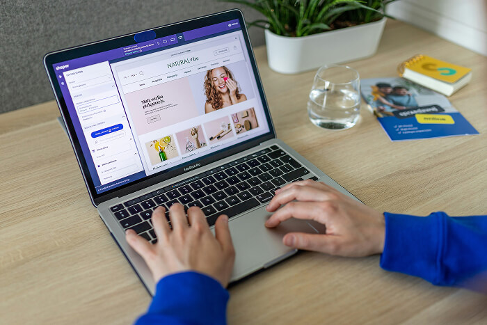 Person using a laptop to design an eCommerce website with a drag-and-drop website builder interface